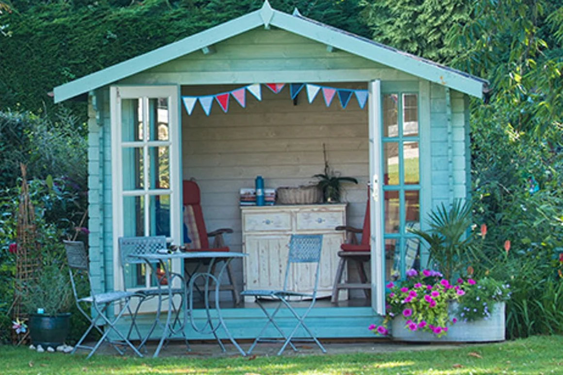 Hellblaues Gartenhaus mit geöffneten Türen und Gartenmöbeln.
